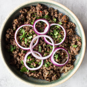 Khara masala keema in bowl with sliced onion and cilantro